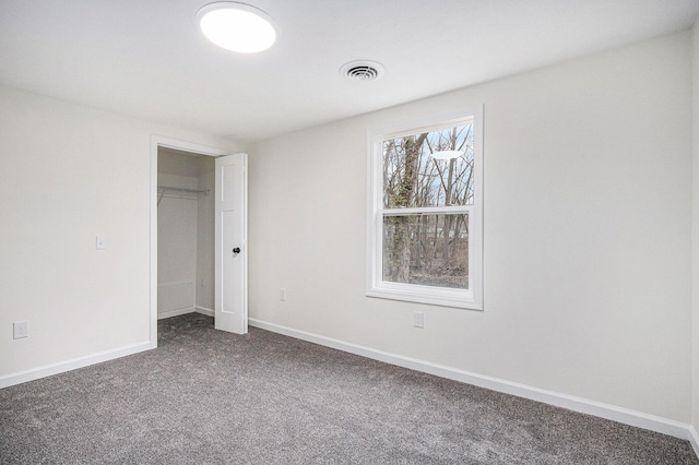 unfurnished bedroom featuring visible vents, baseboards, and dark colored carpet