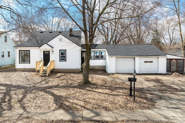 view of front of house featuring a garage, roof with shingles, and a chimney