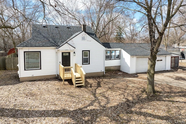 view of front of house featuring a garage, roof with shingles, fence, and driveway