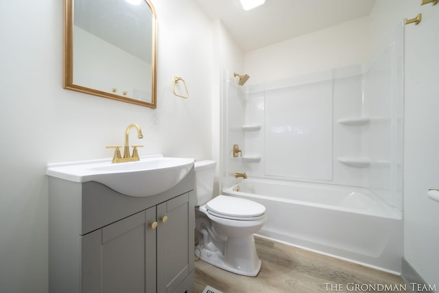 full bath with toilet, shower / bathtub combination, wood finished floors, and vanity