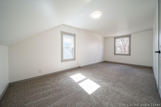 bonus room featuring lofted ceiling, baseboards, and carpet