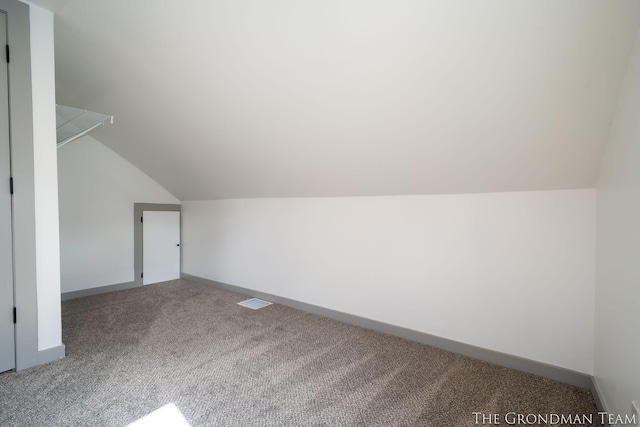 bonus room featuring carpet floors, visible vents, baseboards, and vaulted ceiling