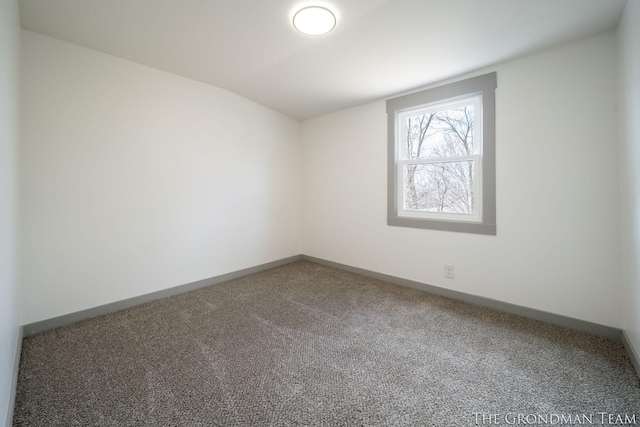 carpeted empty room with baseboards