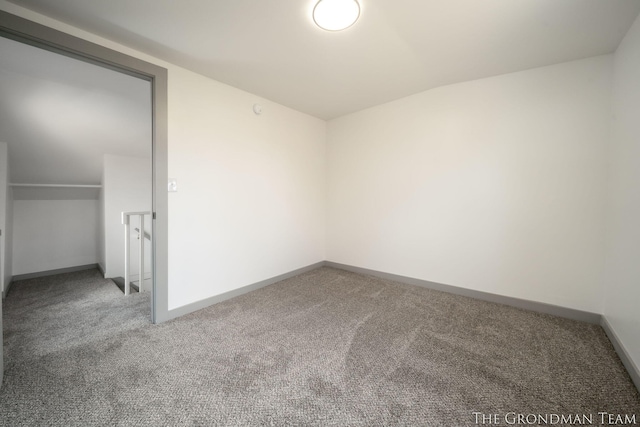 carpeted empty room featuring baseboards