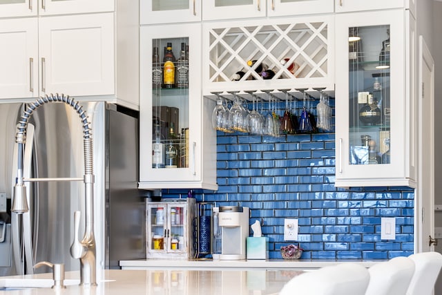 bar featuring a bar and freestanding refrigerator