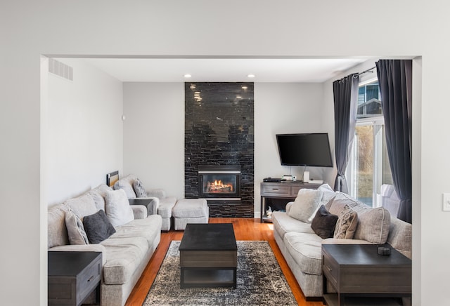 living area featuring recessed lighting, visible vents, wood finished floors, and a fireplace