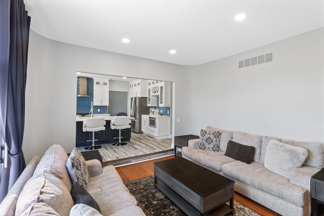 living room with visible vents, recessed lighting, and light wood-type flooring