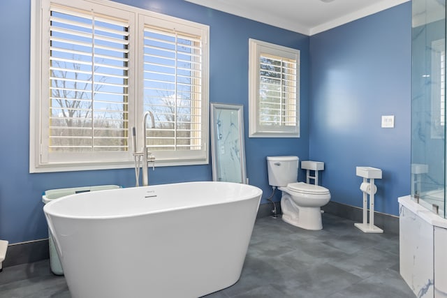 full bathroom featuring baseboards, toilet, ornamental molding, and a freestanding bath