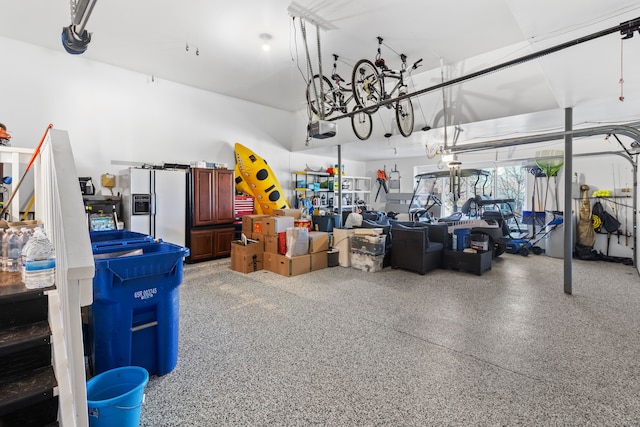 garage featuring white refrigerator with ice dispenser and a garage door opener