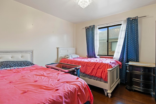 bedroom featuring an inviting chandelier and wood finished floors