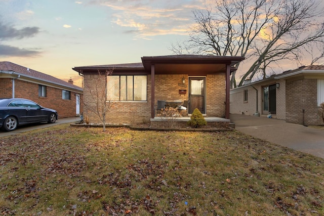 view of front of property with brick siding and a lawn