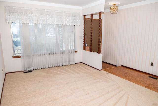 empty room featuring visible vents, a notable chandelier, and baseboards