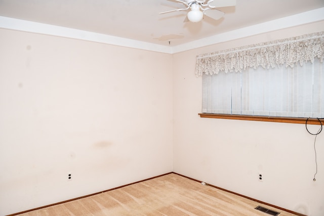 carpeted empty room with a ceiling fan, visible vents, and baseboards