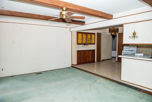 unfurnished living room featuring carpet floors, a ceiling fan, and beamed ceiling