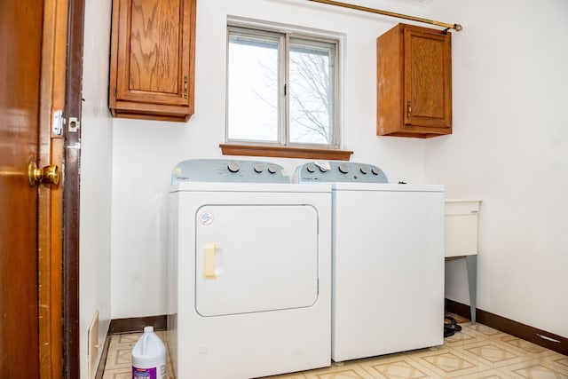 laundry room featuring cabinet space, washing machine and dryer, and baseboards