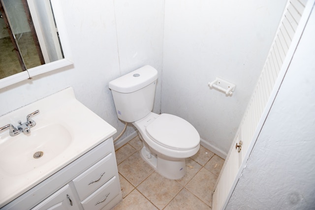 bathroom featuring vanity, tile patterned flooring, toilet, and baseboards