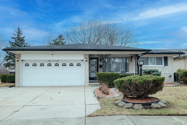 ranch-style house with an attached garage, driveway, roof with shingles, and brick siding