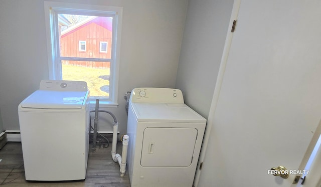 clothes washing area featuring washing machine and dryer, laundry area, and wood finished floors