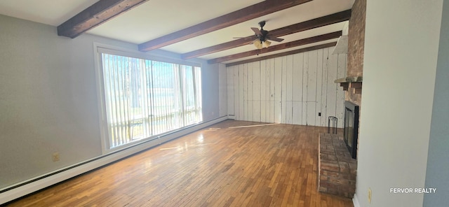 unfurnished living room with hardwood / wood-style flooring, ceiling fan, baseboard heating, a brick fireplace, and beam ceiling