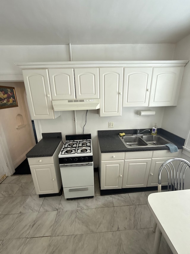 kitchen featuring white cabinets, white gas range oven, under cabinet range hood, and a sink