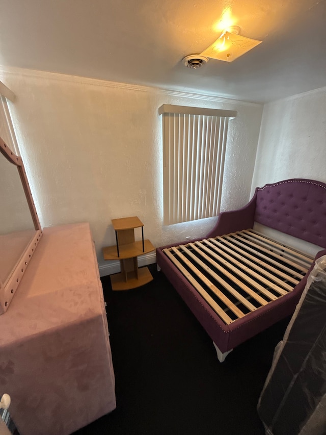 bedroom with visible vents and a textured wall