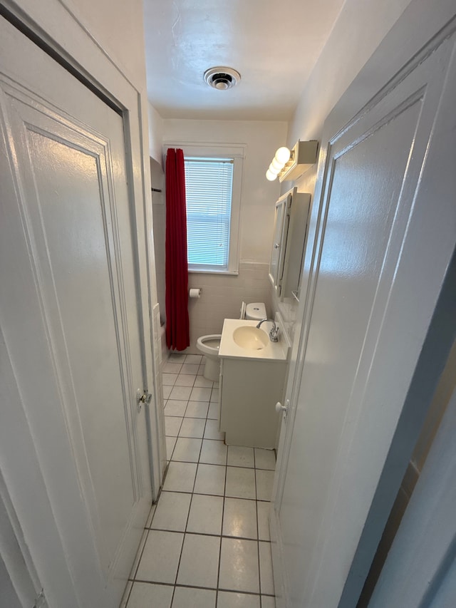 bathroom with visible vents, toilet, tile walls, tile patterned flooring, and vanity