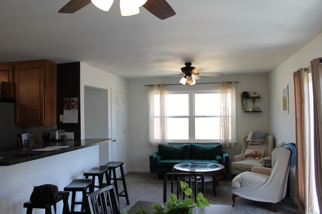 carpeted living room with a ceiling fan