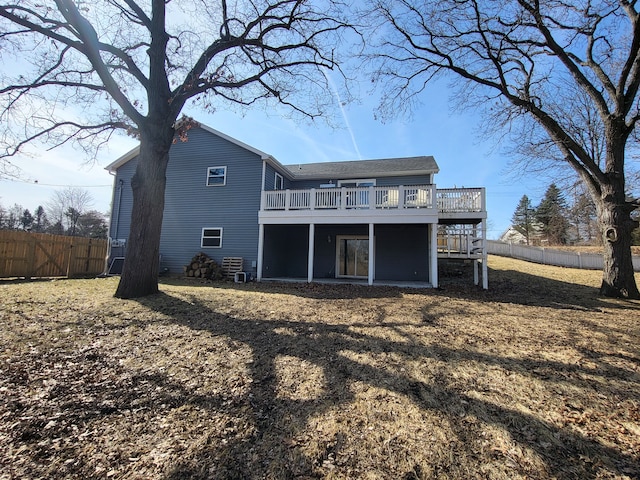 rear view of property featuring fence and a wooden deck