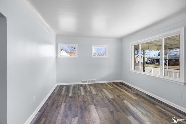 unfurnished room with dark wood-type flooring, baseboards, and visible vents