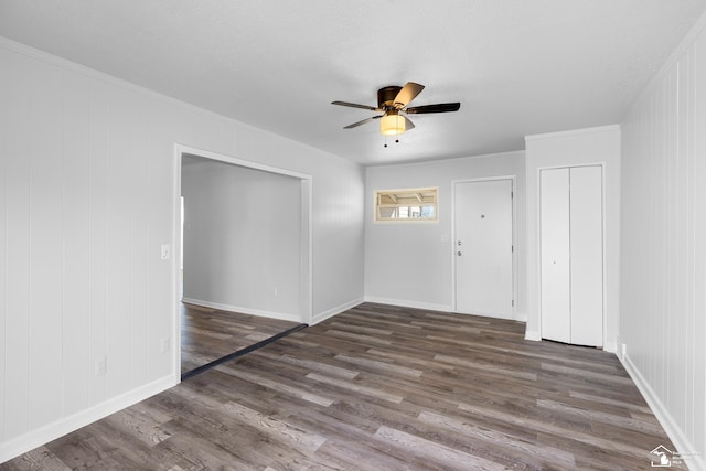 unfurnished room with a ceiling fan, crown molding, wood finished floors, and baseboards