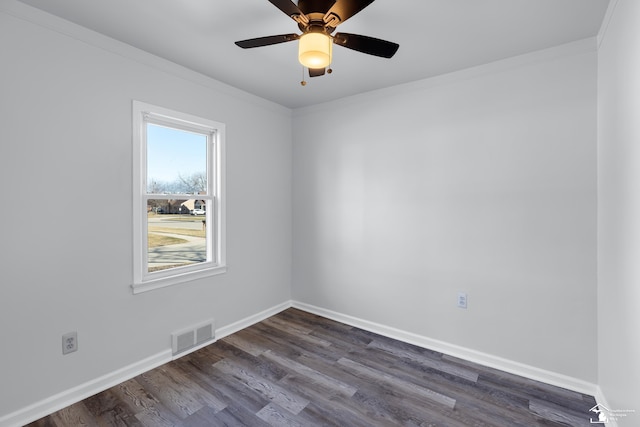 empty room featuring dark wood finished floors, baseboards, visible vents, and ornamental molding