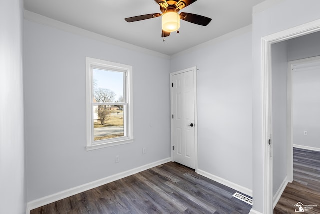 unfurnished bedroom with ceiling fan, baseboards, dark wood finished floors, and ornamental molding