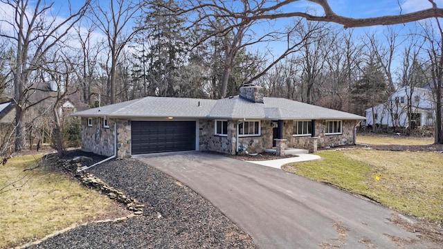 ranch-style home with a front yard, driveway, a chimney, stone siding, and a garage