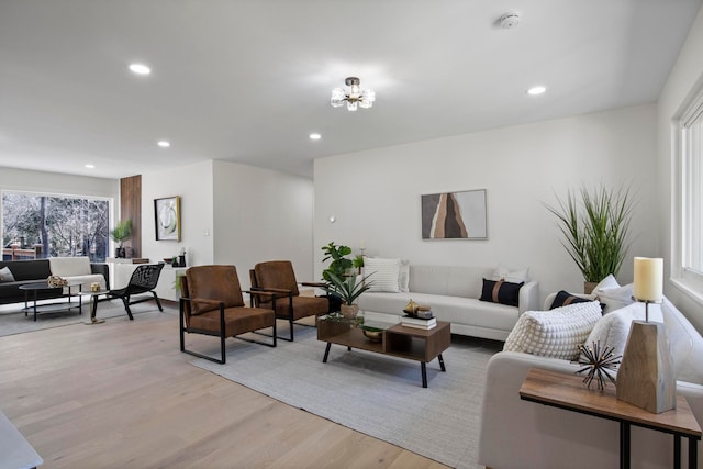 living room with a notable chandelier, recessed lighting, and light wood-type flooring