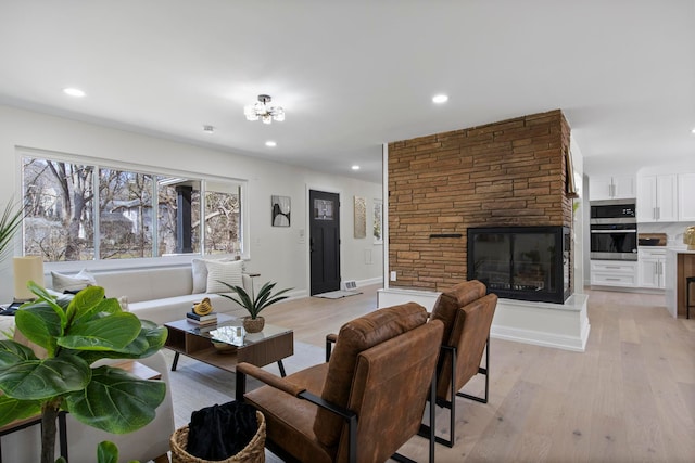 living area with recessed lighting, light wood-style floors, and a fireplace