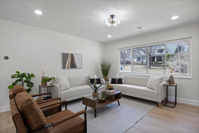 living area with a chandelier, recessed lighting, light wood-style flooring, and baseboards