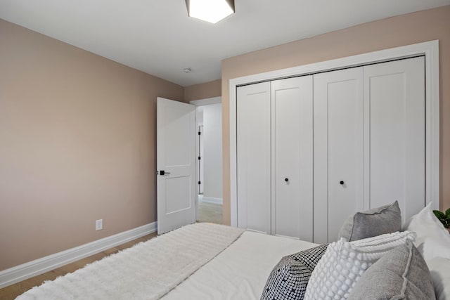 bedroom featuring a closet, baseboards, and wood finished floors