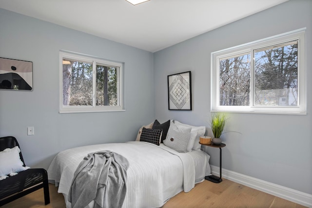 bedroom with baseboards and wood finished floors