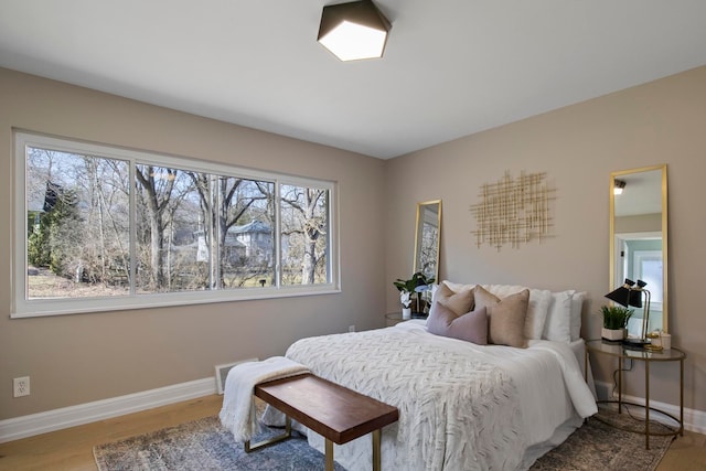 bedroom featuring baseboards and wood finished floors