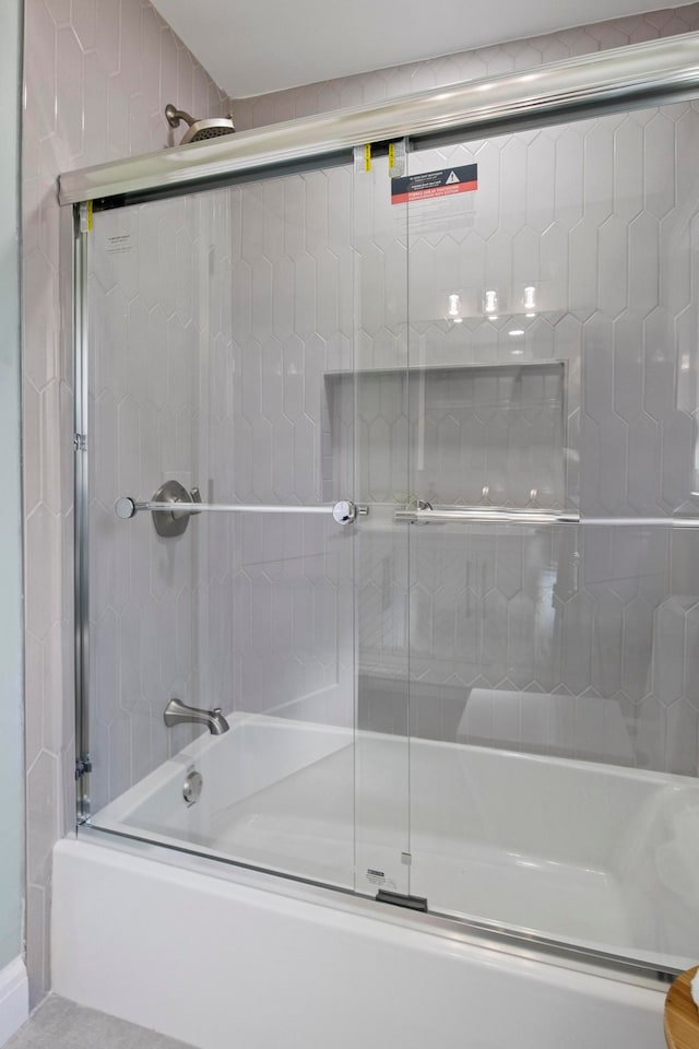 bathroom featuring bath / shower combo with glass door