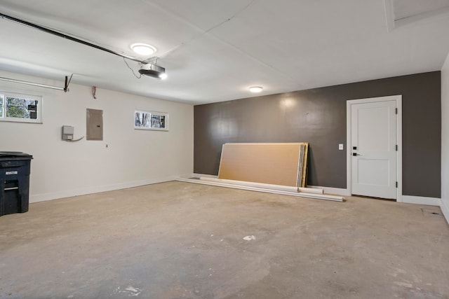 garage with electric panel, a garage door opener, and baseboards