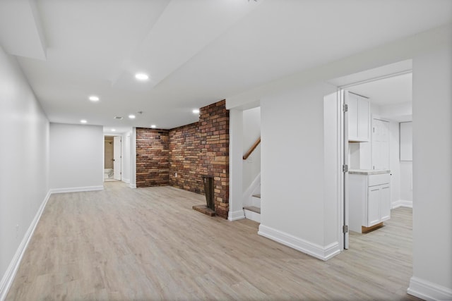 finished basement featuring recessed lighting, baseboards, stairs, and light wood-style floors