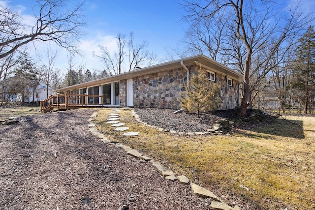 rear view of property with stone siding and a deck