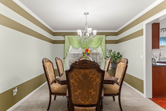 carpeted dining area featuring a sink, ornamental molding, baseboards, and a chandelier