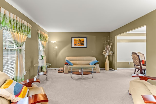 carpeted living room featuring baseboards