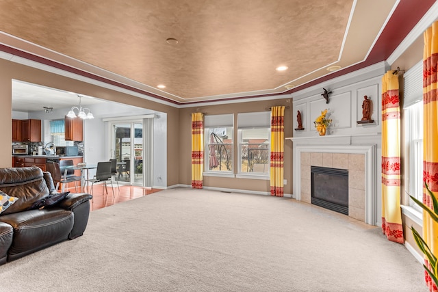 living room featuring light carpet, a chandelier, a tile fireplace, and baseboards