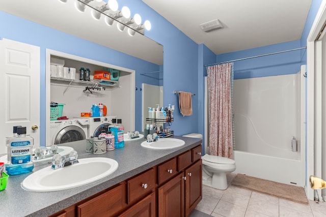 bathroom with tile patterned floors, separate washer and dryer, toilet, and a sink