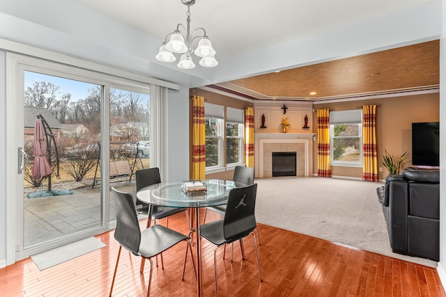 dining room featuring a notable chandelier, a fireplace, and wood-type flooring