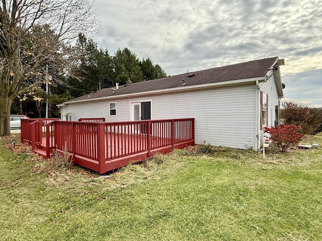 back of house with a wooden deck and a lawn