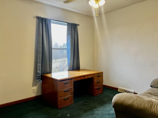 office area featuring visible vents, baseboards, dark colored carpet, and ceiling fan